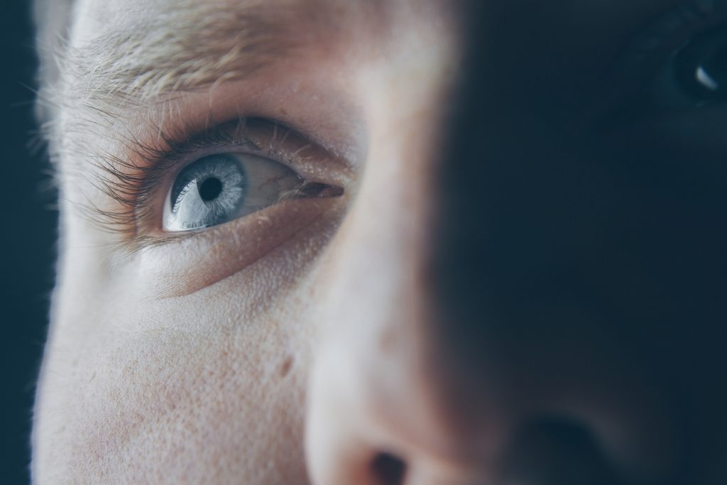 Closeup of a man's face with the left side of his face in shadow and right in full light