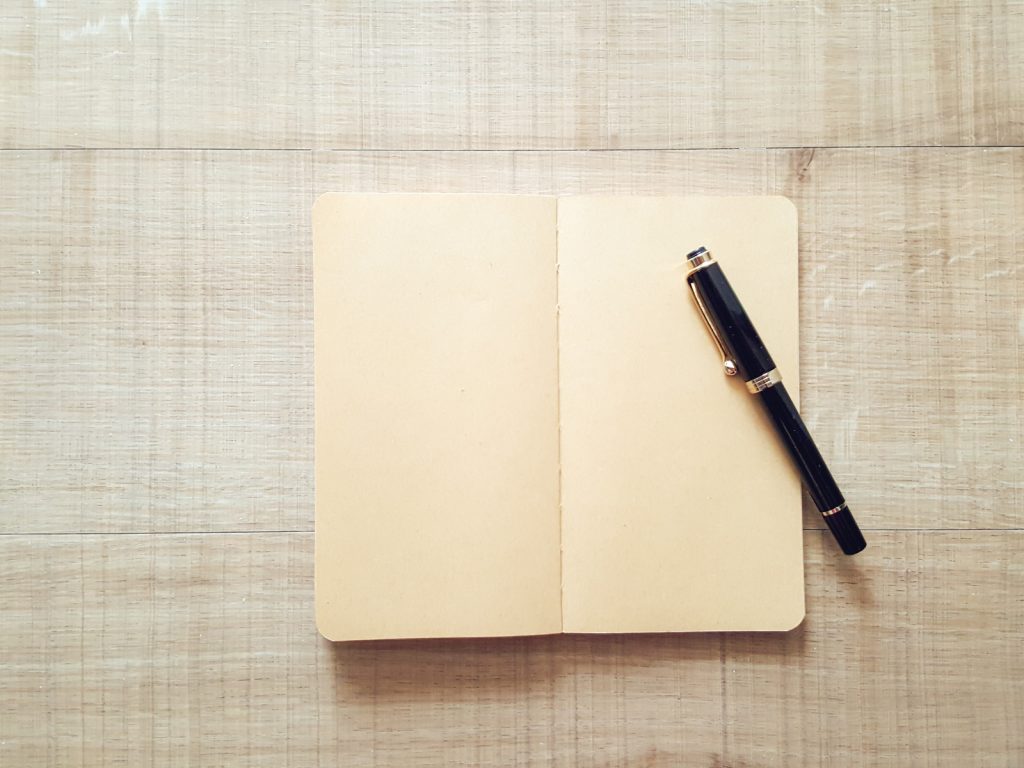 tan blank journal with pen