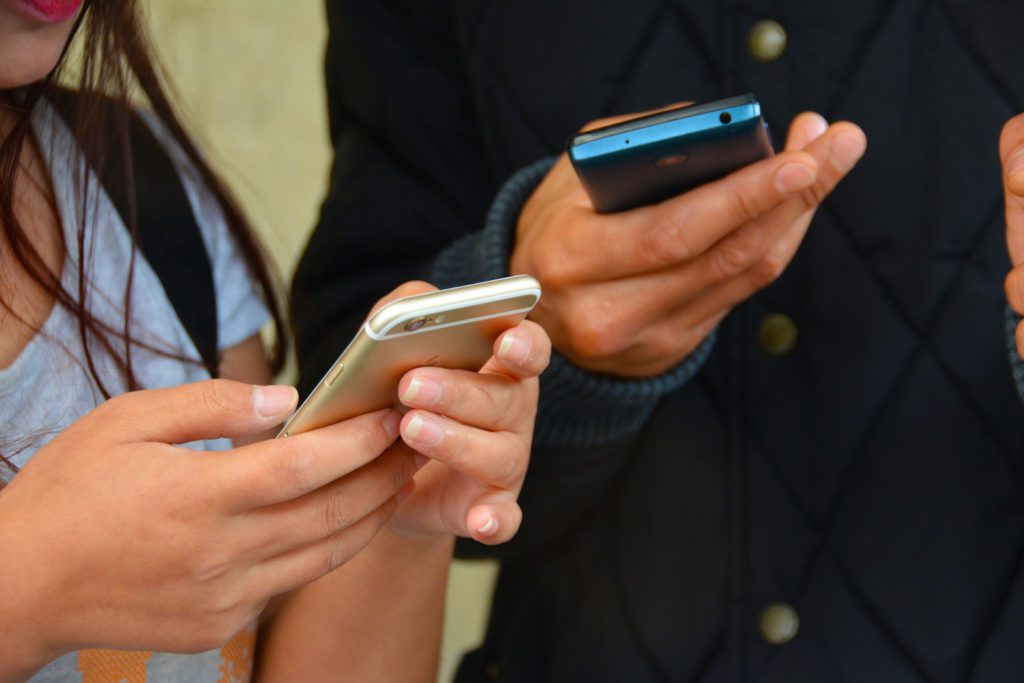 Two people holding phones