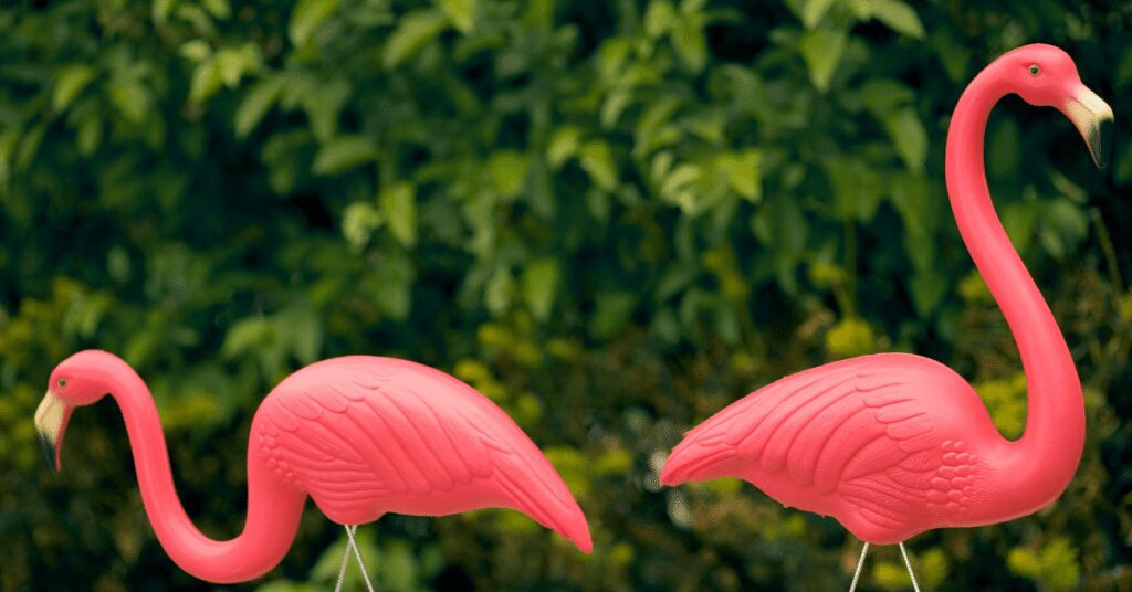 Closeup of two pink lawn flamingos. 
