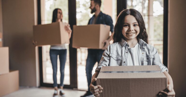 Child holding moving boxes.