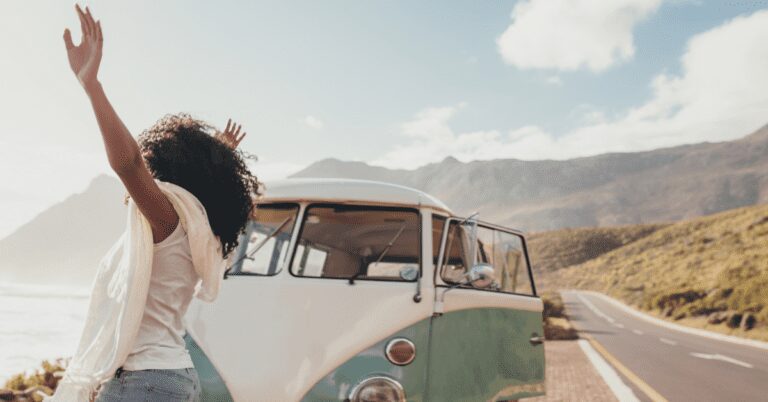 Woman with VW bus at seaside.