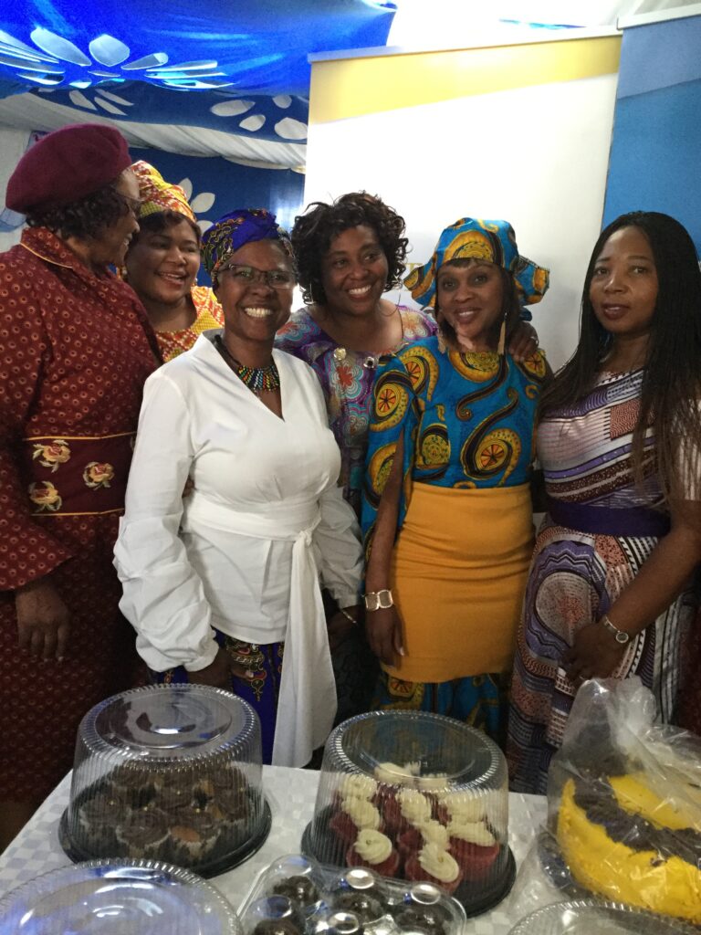 Six women in a mixture of contemporary and African-style dresses.