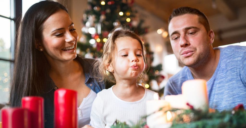 Two parents and child with Advent candles.