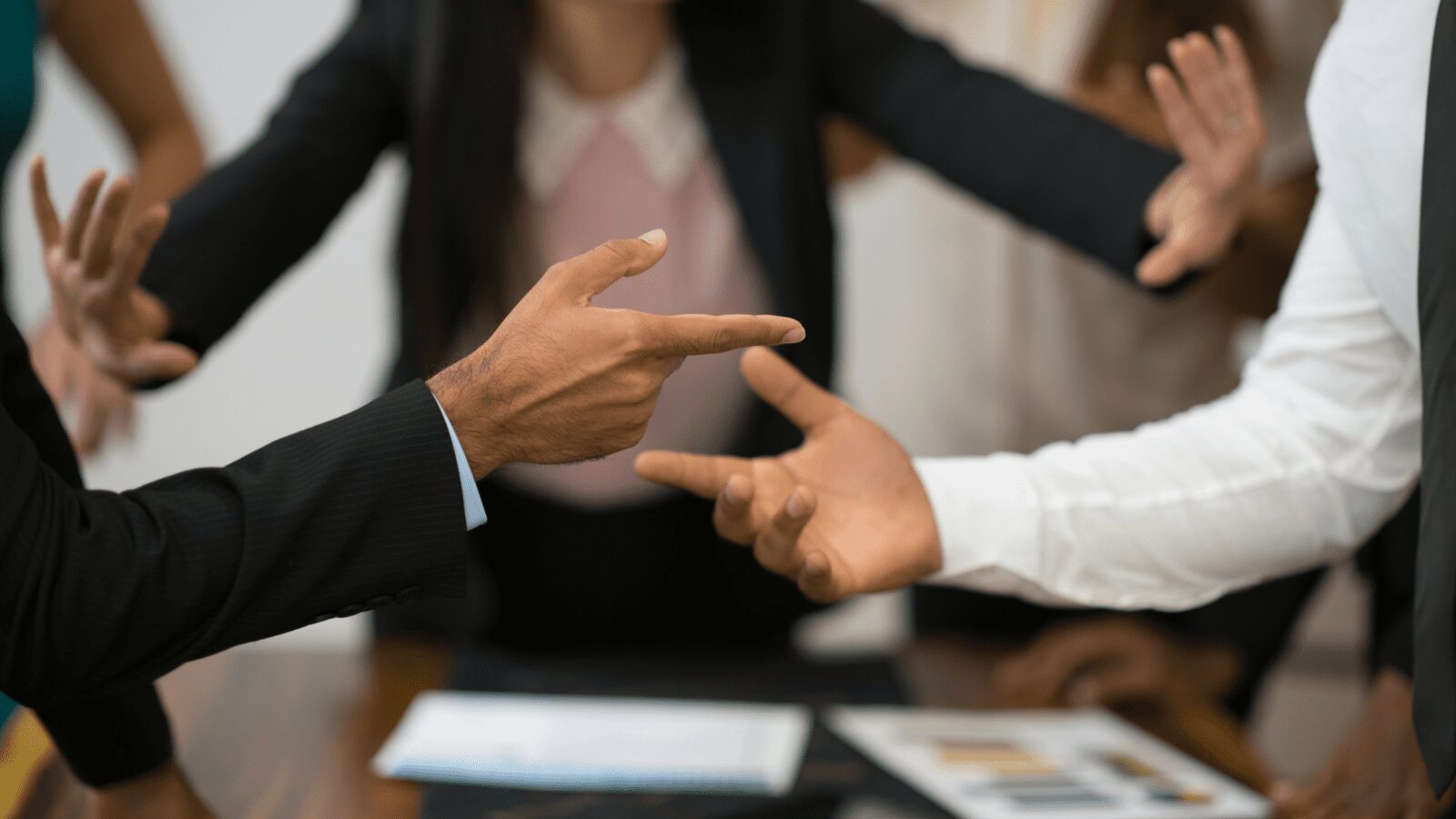 Hands held up in an argument during a meeting.