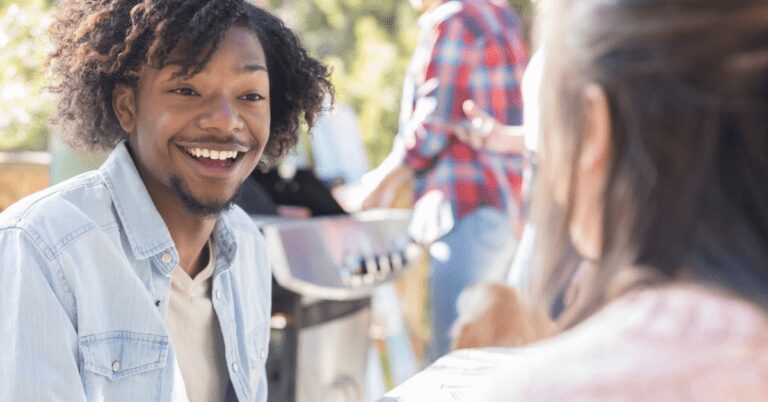 Man smiling while talking to a woman.
