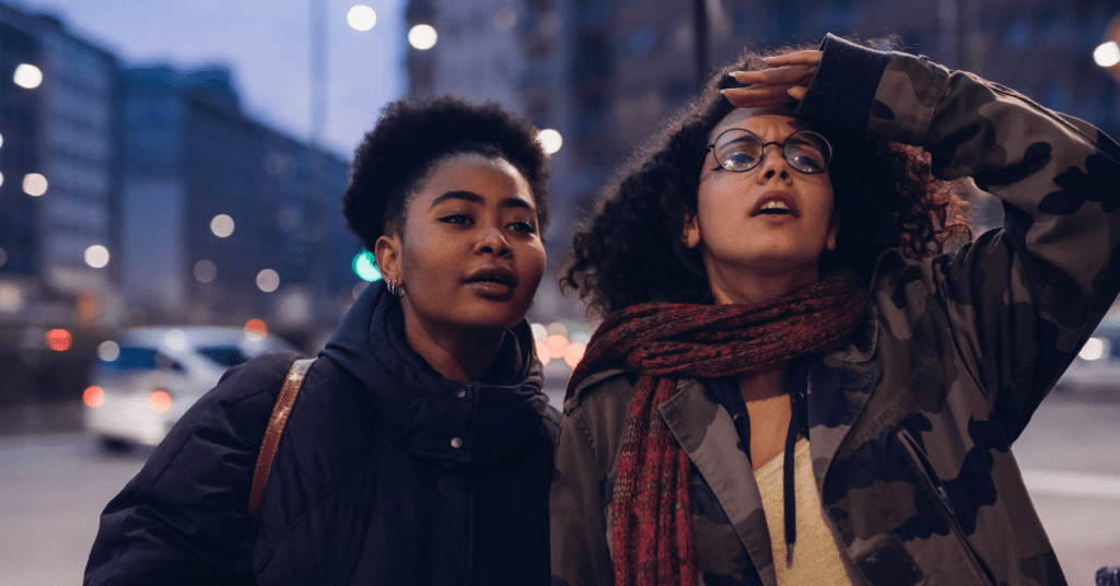 Two women outside in a city looking ahead.