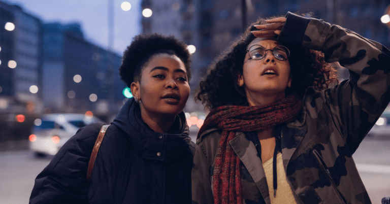 Two women outside in a city looking ahead.
