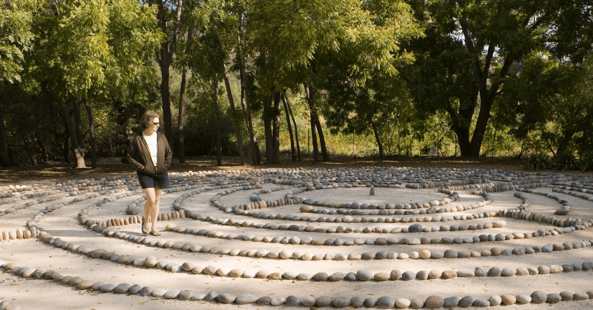 Woman walking a stone prayer labyrinth.