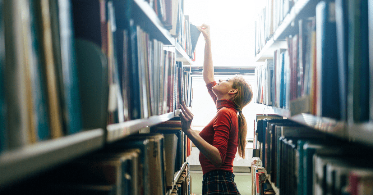 woman looking through library shelves