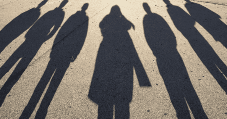 long, ominous shadows of people on concrete