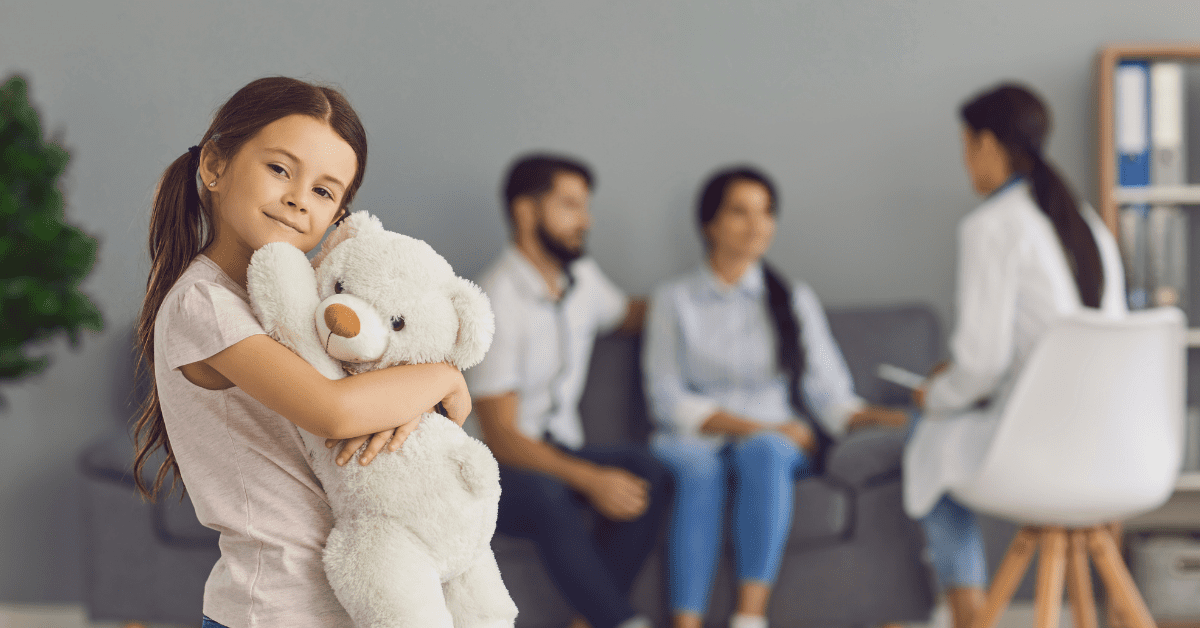 smiling little girl hugging a big teddy bear