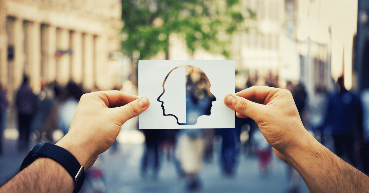 two hands holding a card picturing 2-sided profile of a person's head