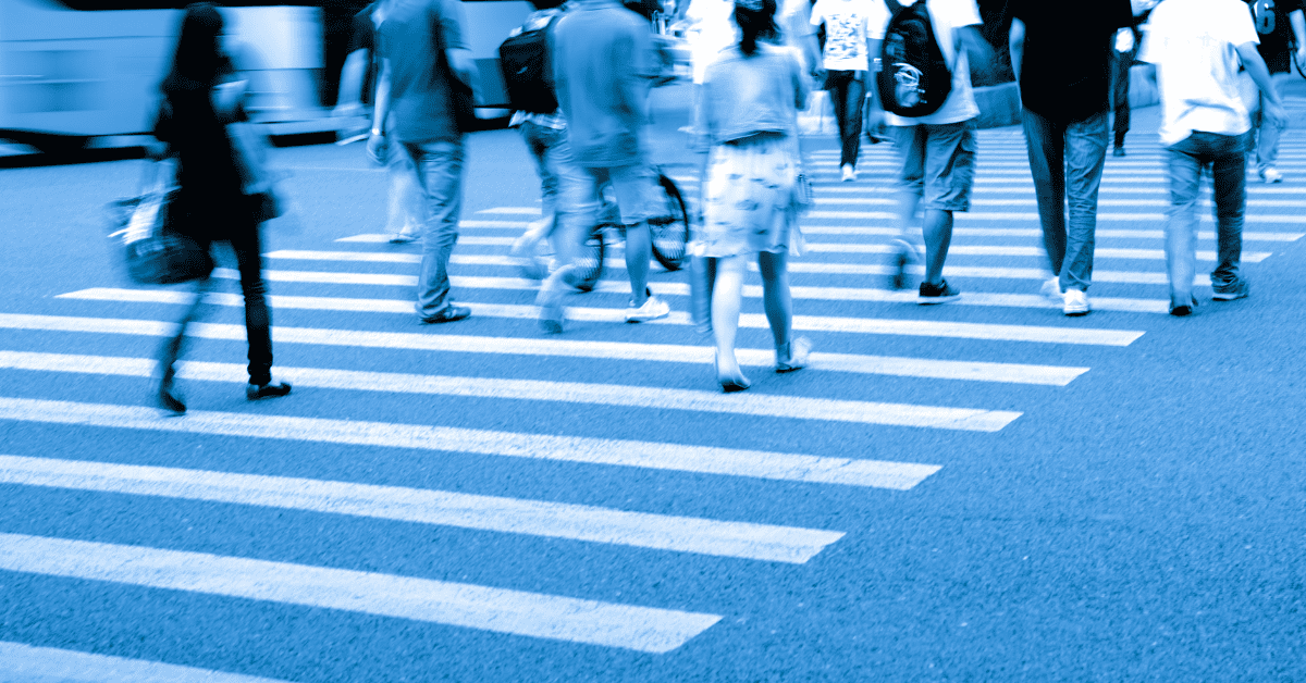 People crossing the street quickly. Image has a blue filter over it.