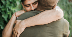 Two friends embracing one another for comfort.