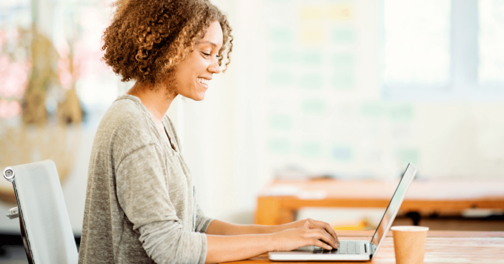 young woman at her desk working on her laptop