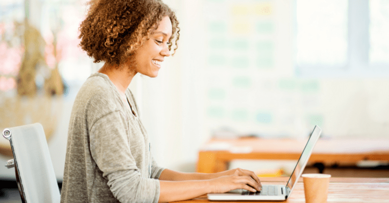 young woman at her desk working on her laptop
