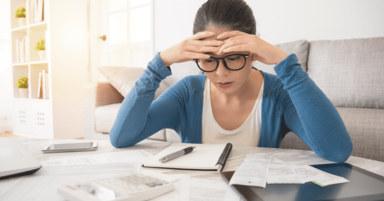 woman with her head in her hands looking at paperwork