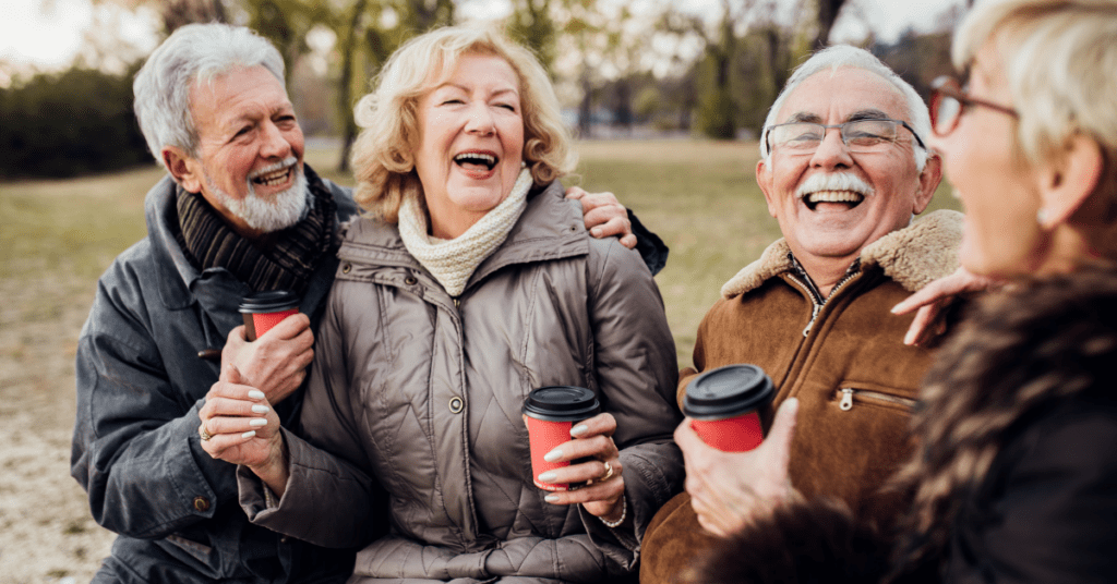 four old friends drinking coffee and laughing together
