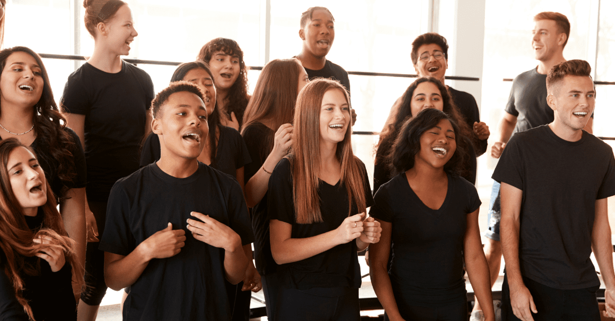 a happy choir singing wearing black t-shirts