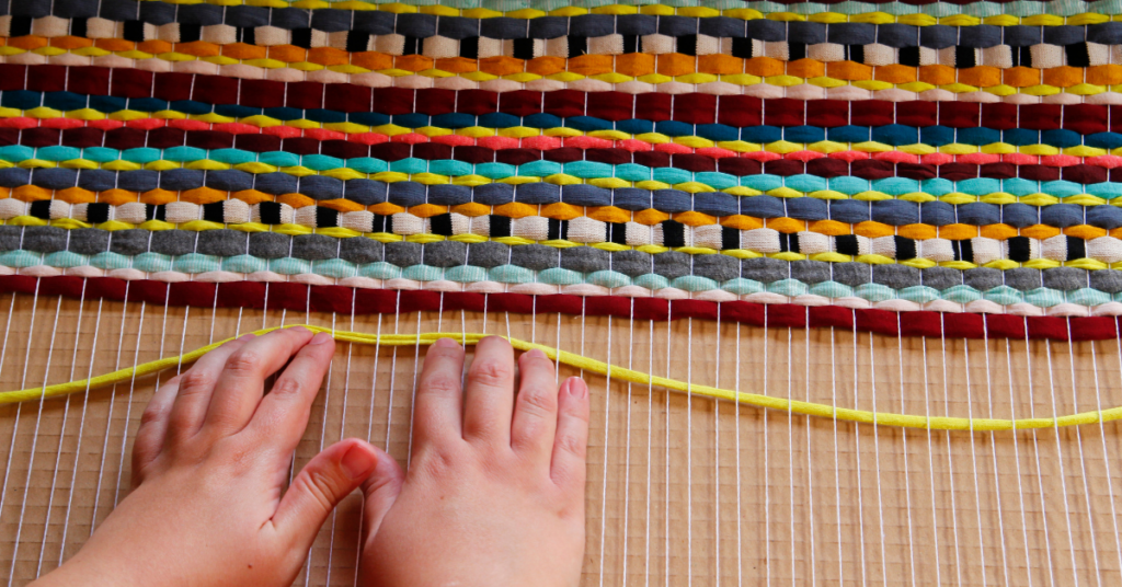 small hands pushing up sting while weaving
