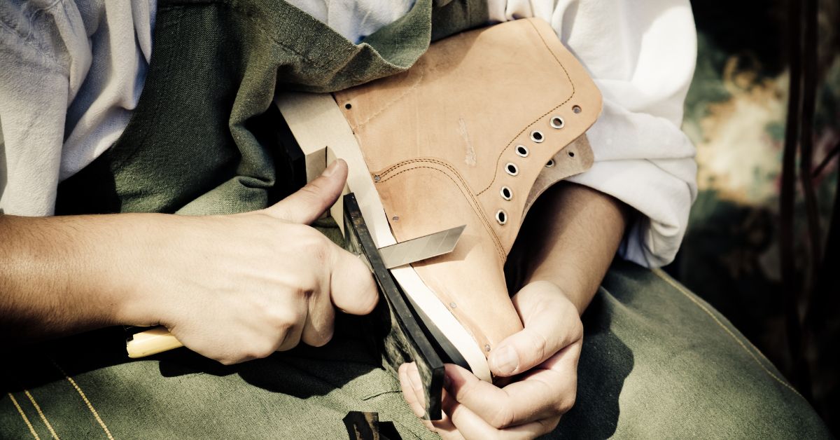 shoe cobbler trimming a boot