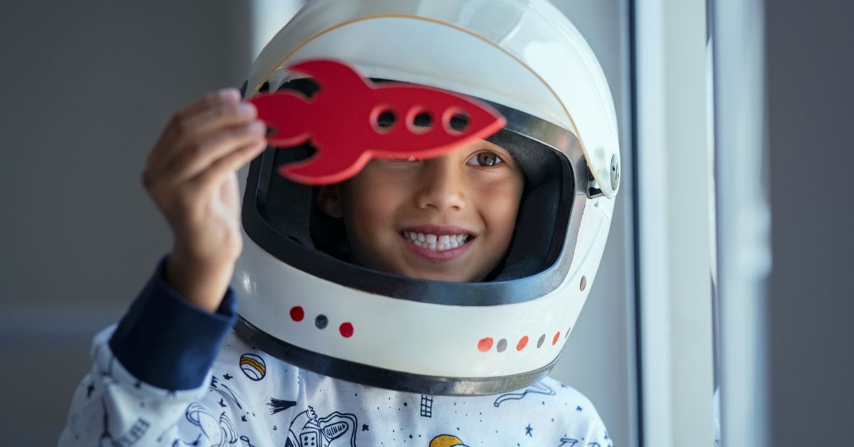 young child playing in an astronaut helmet