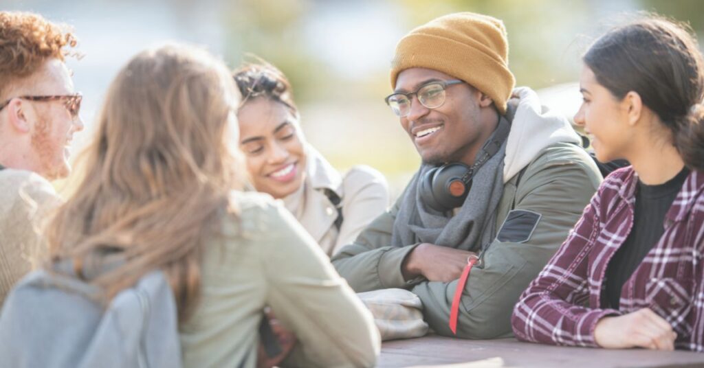 friends talking around a table outside