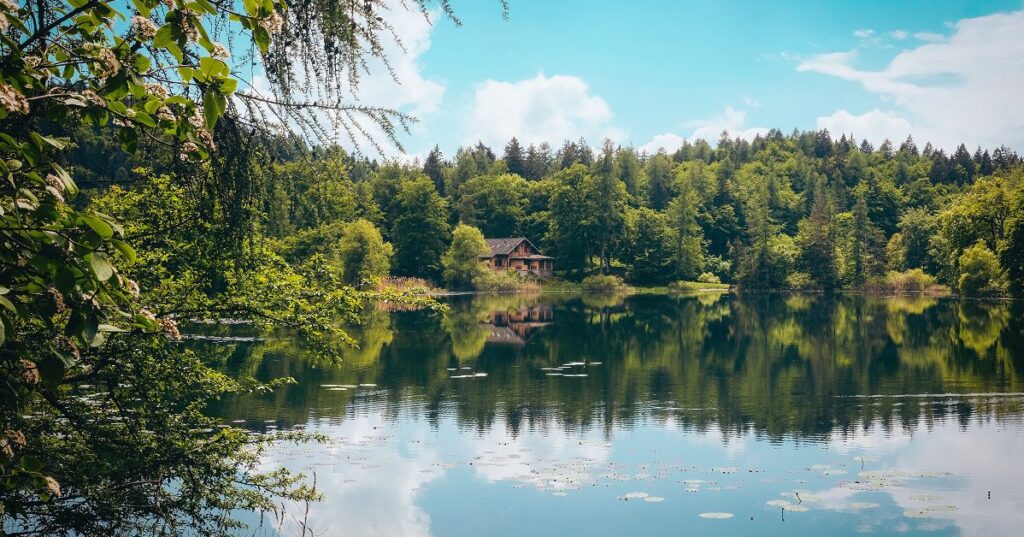 Large cabin next to reflective lake