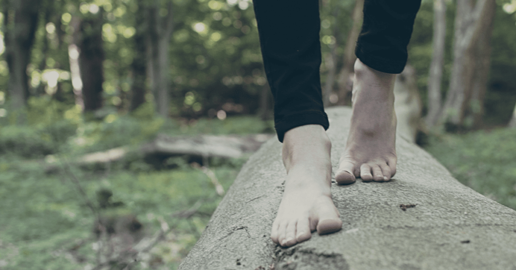 photo of feet balancing on log