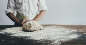 photo of a person with a ball of bread dough