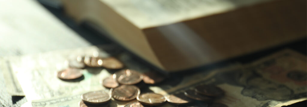 Close-up of US currency (pennies and dollar bills) next to a book