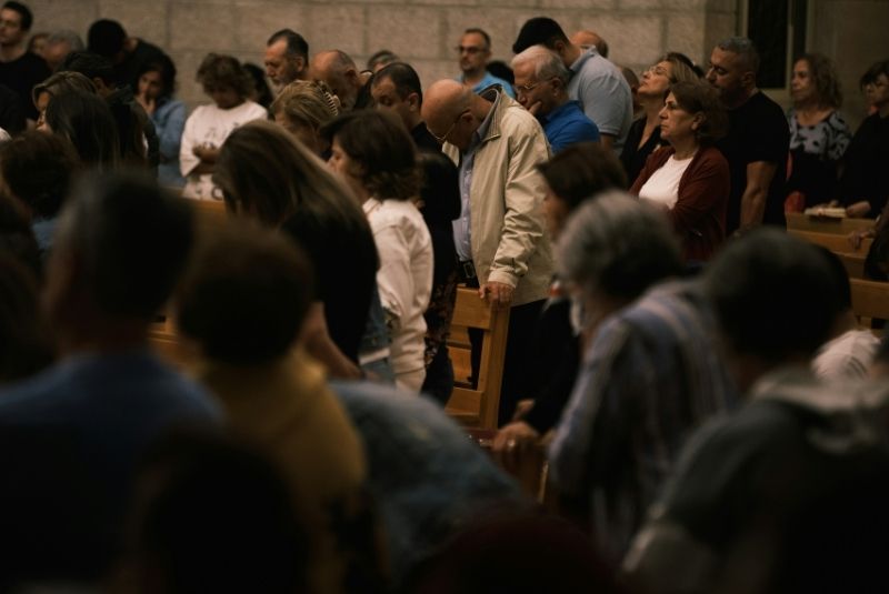 Man standing in worship service surrounded by people