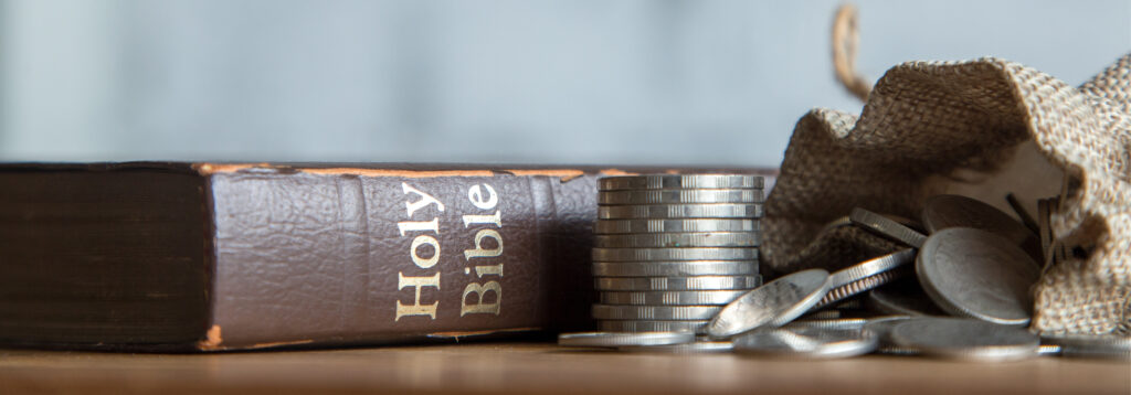 Gemini said A leather-bound Holy Bible resting next to a stack of silver coins and an open burlap sack spilling more coins.