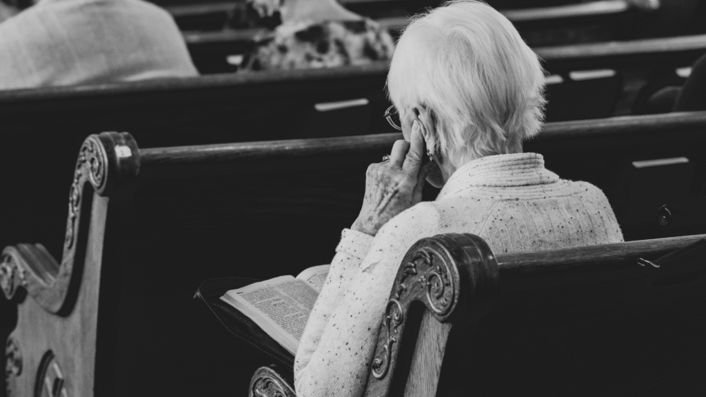 photo of an elderly woman in a church pew