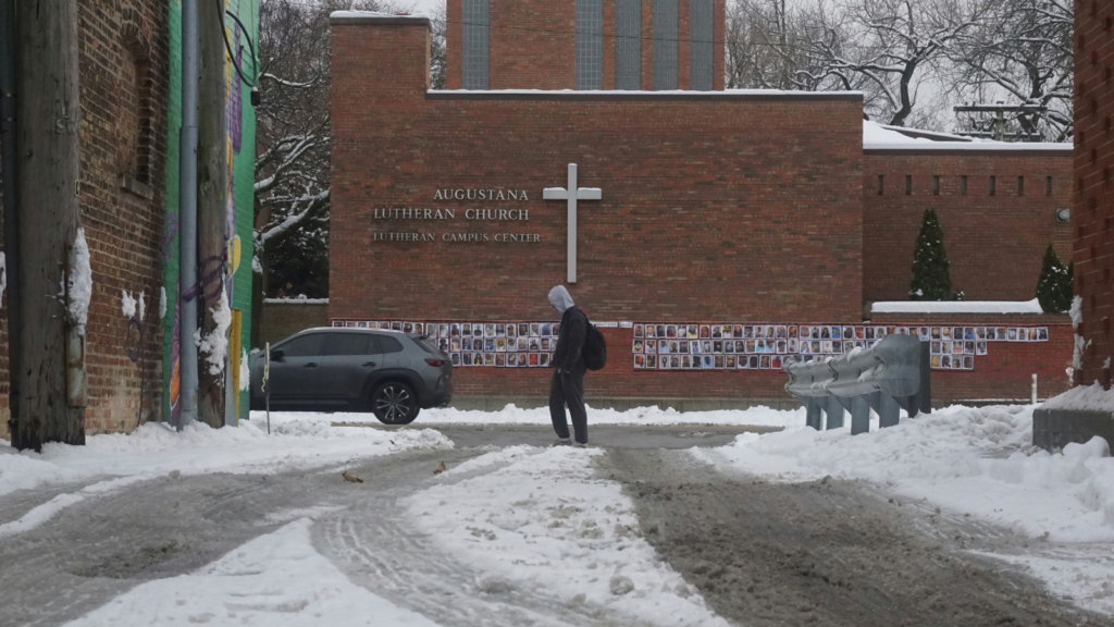 photo of a man walking in front of a church in winter alone