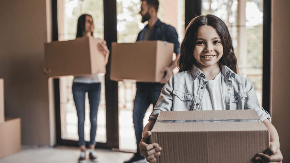 Child holding moving boxes.