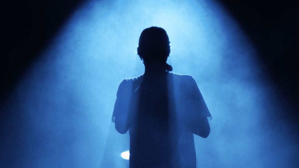 performer standing in a spotlight