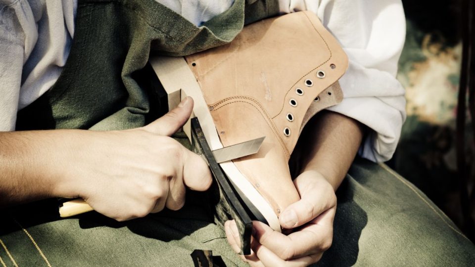 shoe cobbler trimming a boot