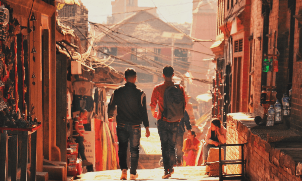 two men walking away in a eastern, rural city