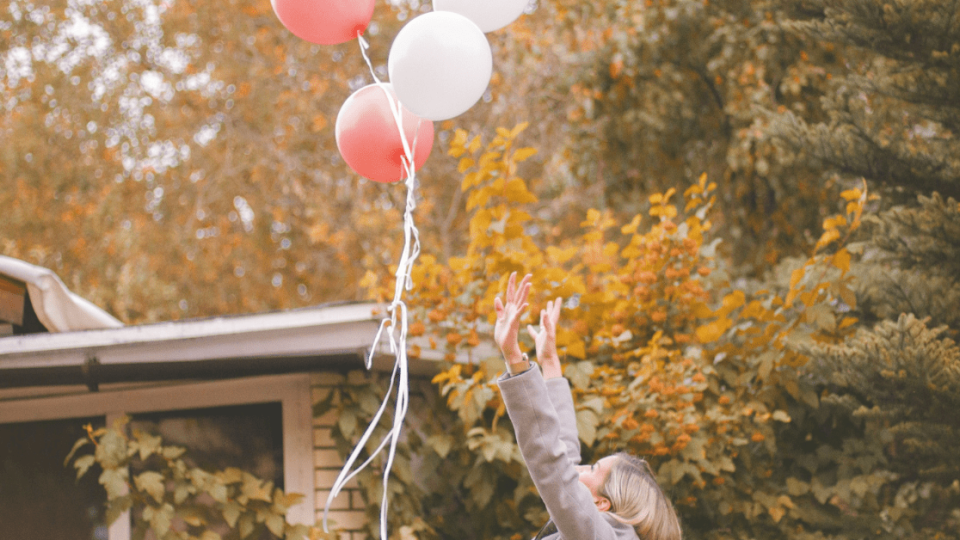 woman-releasing-balloons-into-the-air
